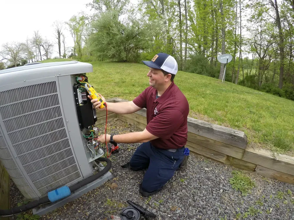 Electrician working on outdoor AC unit in Warrenton, VA.