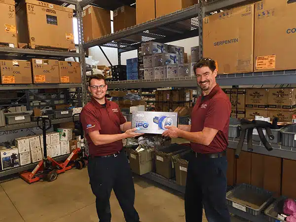 Two HVAC installers holding an Air Knight